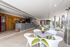 A modern restaurant with white wicker chairs and a bar area. - Holiday Club Puerto Calma (Mogan)