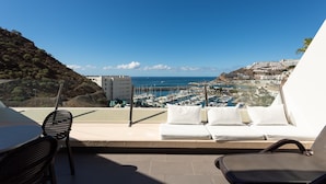 A balcony with a view of a marina and coastal town.