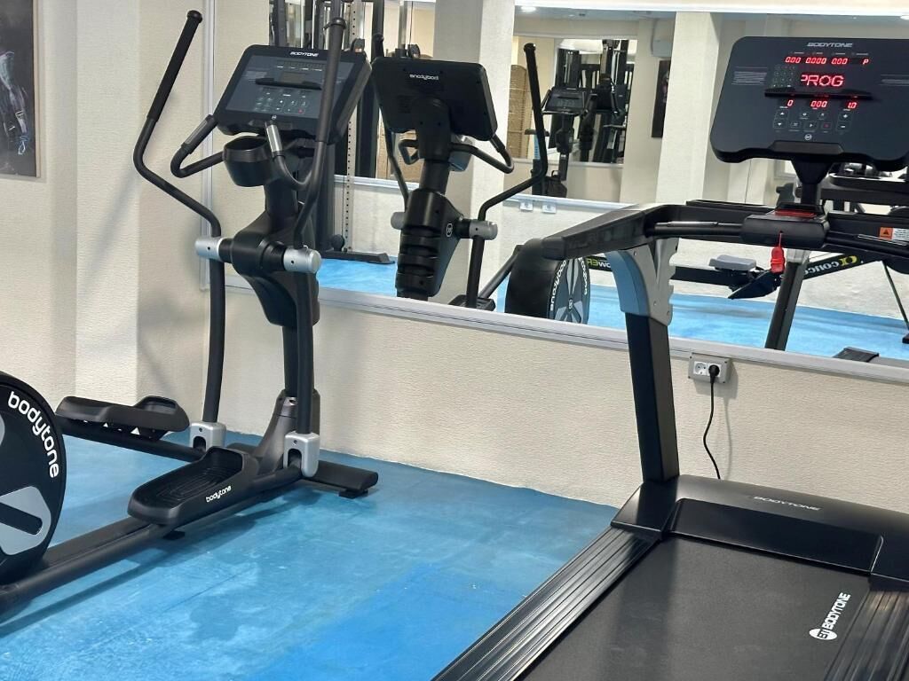 Una palestra con attrezzature cardio, tra cui tapis roulant ed ellittica.