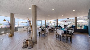 A spacious indoor area with high ceilings, large windows, and a view of the city.