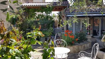 Relax in a serene garden setting surrounded by vibrant flowers and lush greenery, with a tranquil atmosphere perfect for unwinding.