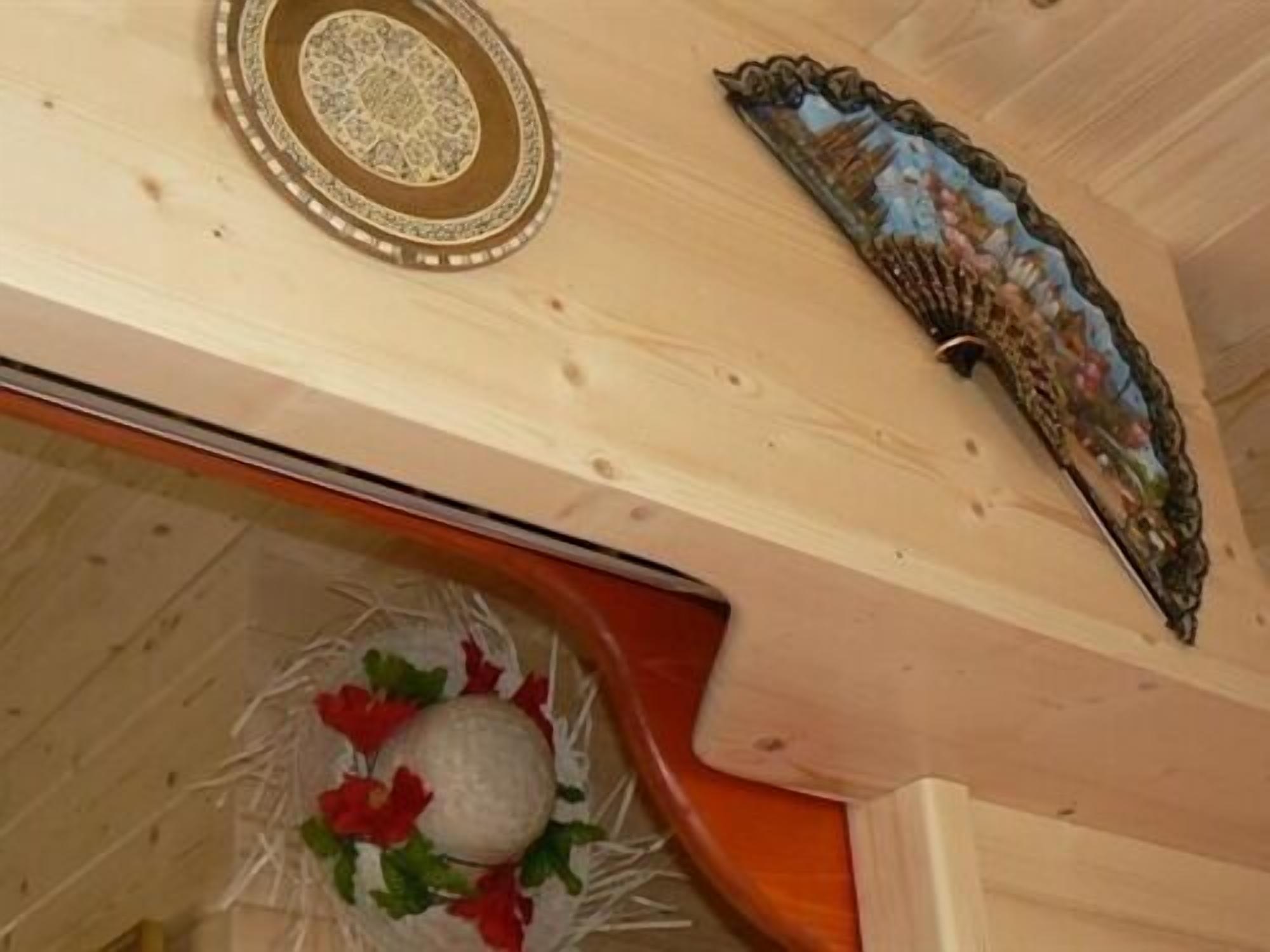 Techo de madera con un adorno decorativo y una obra de arte enmarcada.