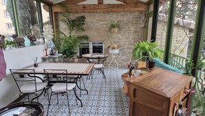 Un espace patio accueillant, doté d’un bar en bois, d’un sol carrelé et de plusieurs tables et chaises.