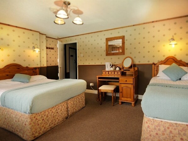 A room with two beds, a wooden desk, a chair, and a mirror. - The Mount Inn (Llanidloes)