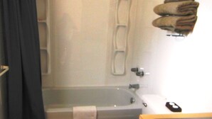 A bathroom with a bathtub, a towel rack with towels, and a toilet. - Cataline Motel & RV Park (South Hazelton)