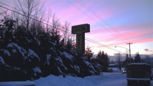A snow-covered landscape with a motel sign labeled "CATALINE MOTEL" against a sunset sky. - Cataline Motel & RV Park (South Hazelton)