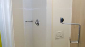 A bathroom with a shower, toilet, and a towel rack.
