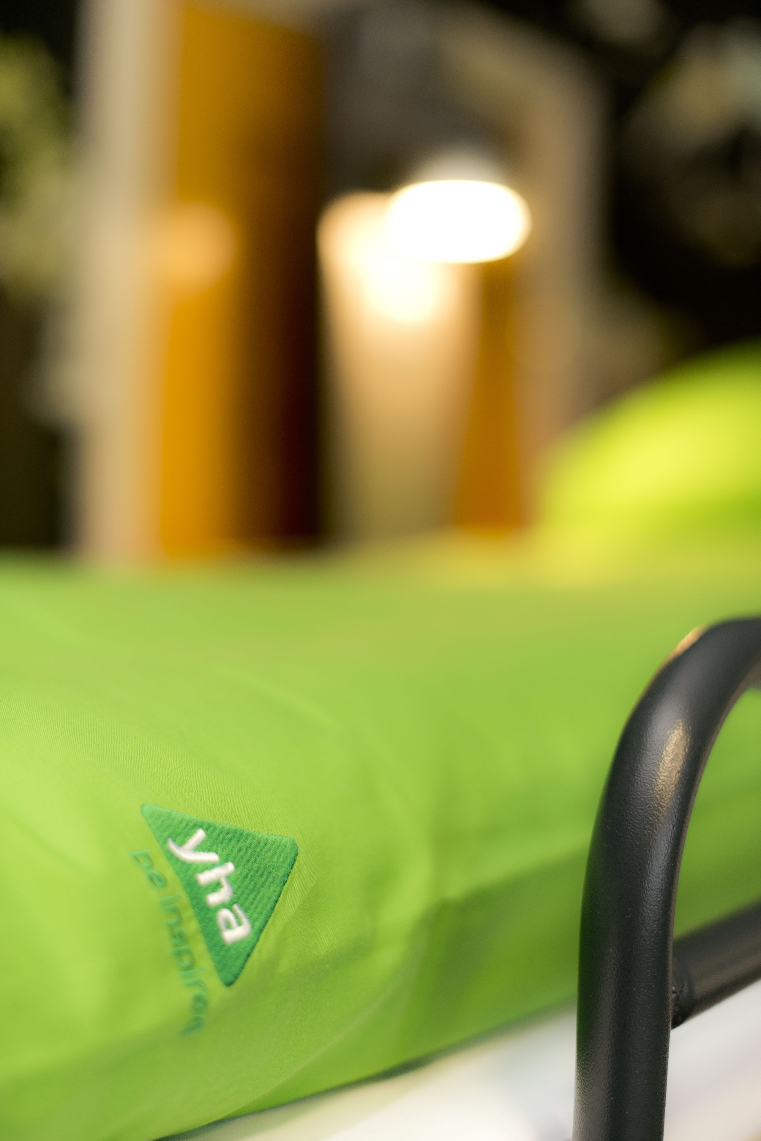 A close-up of a green bag with the logo "yha" and the text "be inspired".