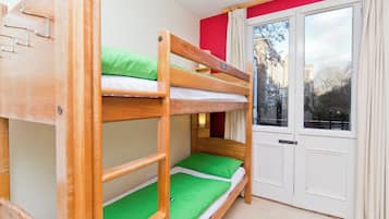 Habitación con literas, ventana y cortinas.
