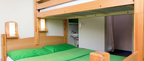 Una cama litera con colchón verde y cabecero de madera.