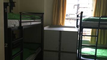 Ein Schlafraum mit Etagenbett, Fenster und Schreibtisch.