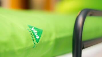 Primer plano de un objeto verde con un logotipo y texto, probablemente parte de un mueble o equipo.