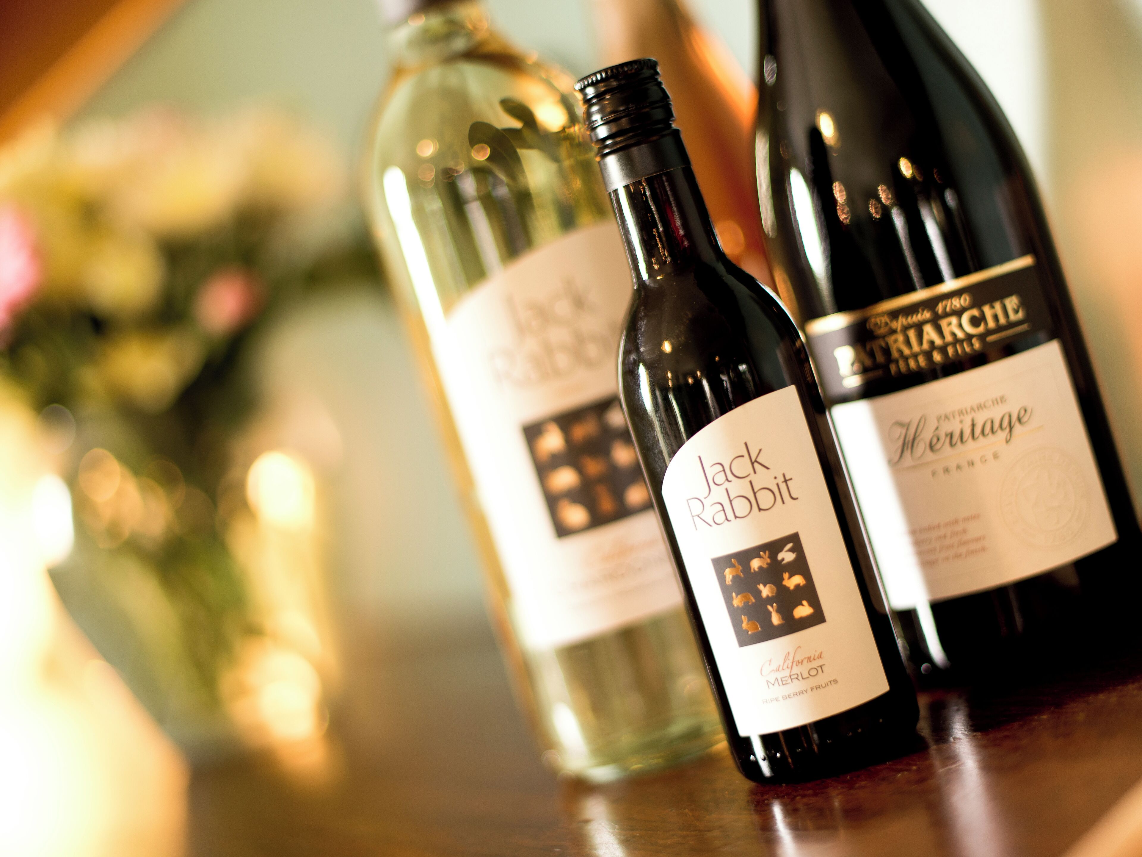 Tres botellas de vino sobre una superficie de madera.