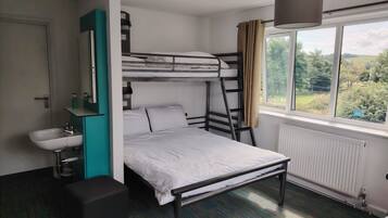 A bunk bed room with a window, a sink, and a radiator.
