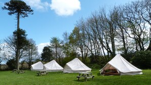 A campsite with several white tents and picnic tables. - YHA Penzance - Hostel (Penzance)