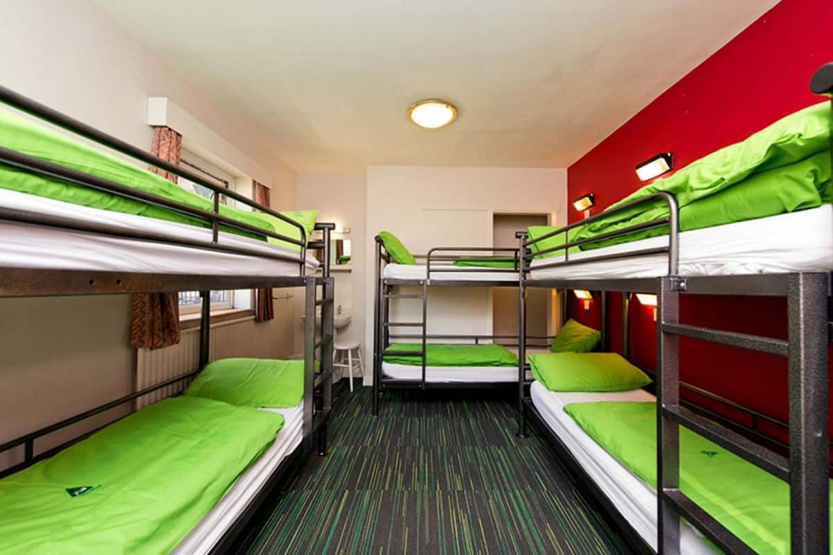 Un dormitorio con literas, un escritorio pequeño y una silla.