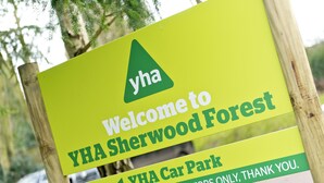 Skilt, der byder besøgende velkommen til YHA Sherwood Forest, og angiver at det er et område for gæsteparkering.