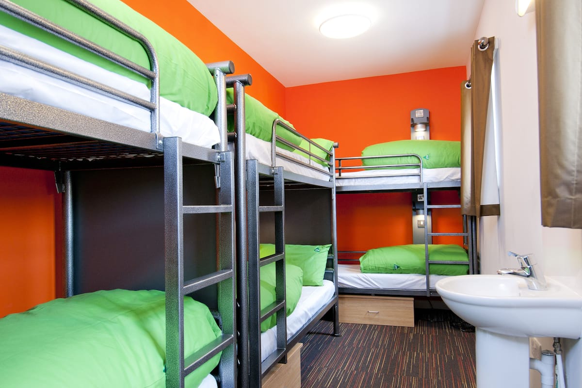 A bunk bed room with a sink and a mirror.