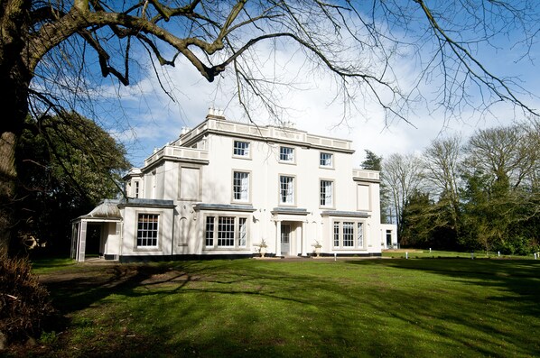 A large, white, two-story building with multiple windows and a well-maintained lawn. - YHA Stratford-upon-Avon - Hostel (Stratford-upon-Avon)