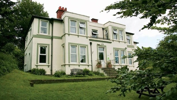A two-story house with a front garden, a bench, and a staircase leading to the entrance. - YHA Streatley - Hostel (Reading)