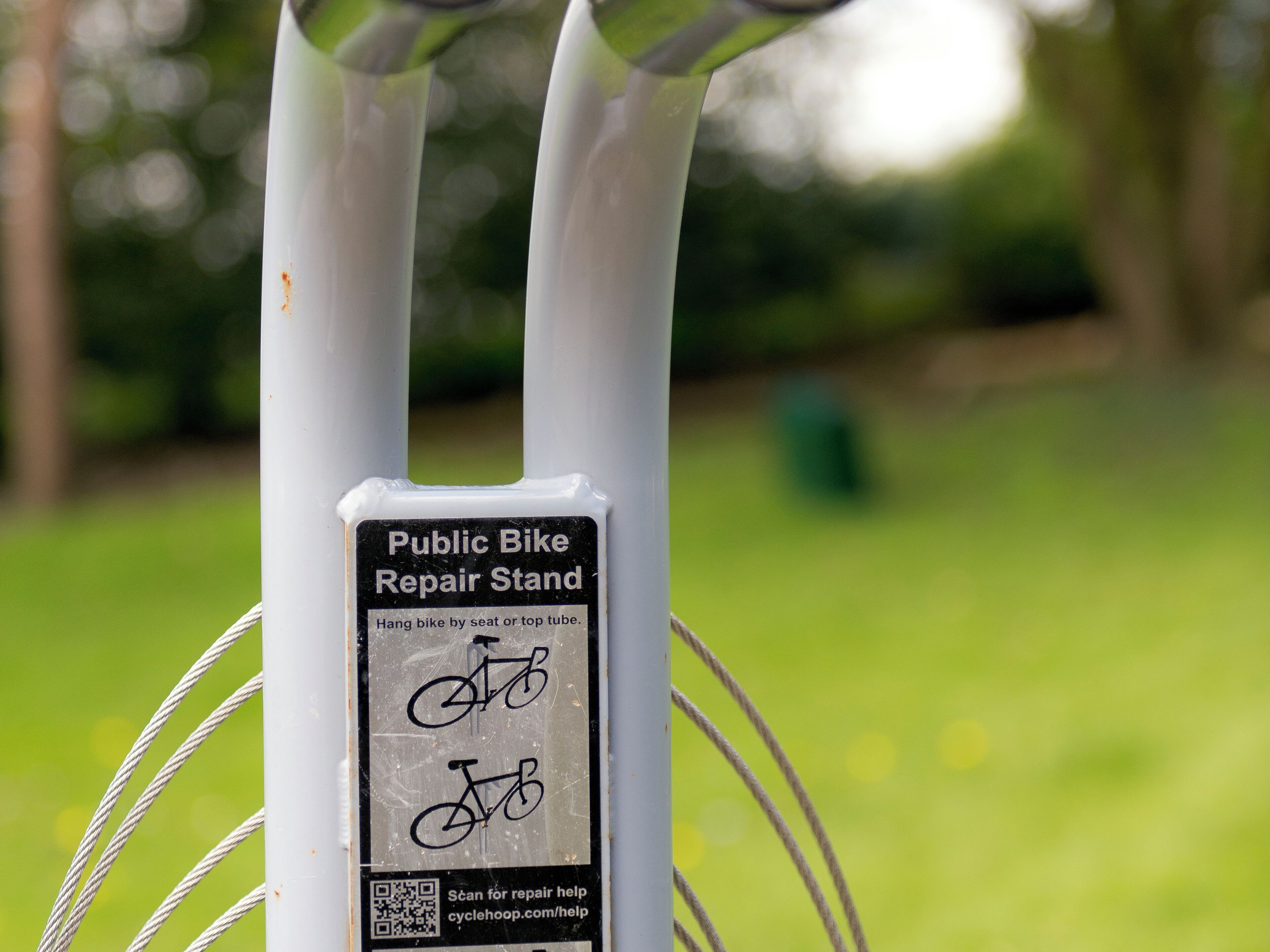A public bike repair stand with a QR code for repair help.