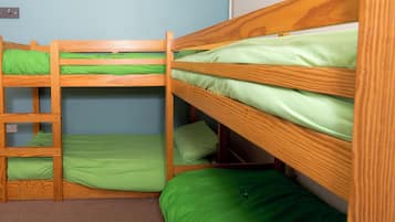 A bunk bed room with green bedding and a brown carpet.