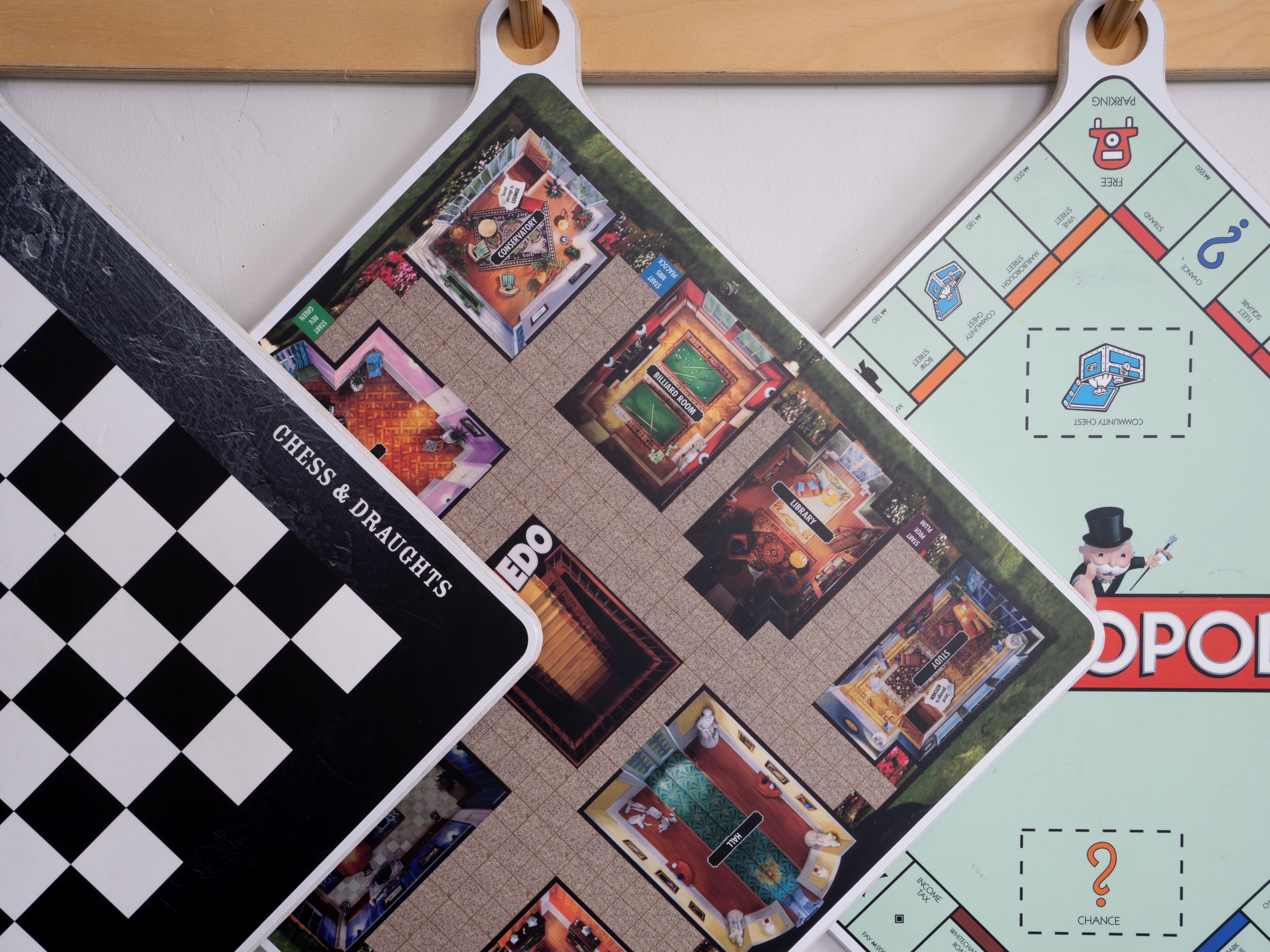 A board game with various room layouts and labels such as "Chess & Draughts," "Library," and "Community Chest."
