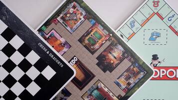 A board game with various room layouts and labels such as "Chess & Draughts," "Library," and "Community Chest."