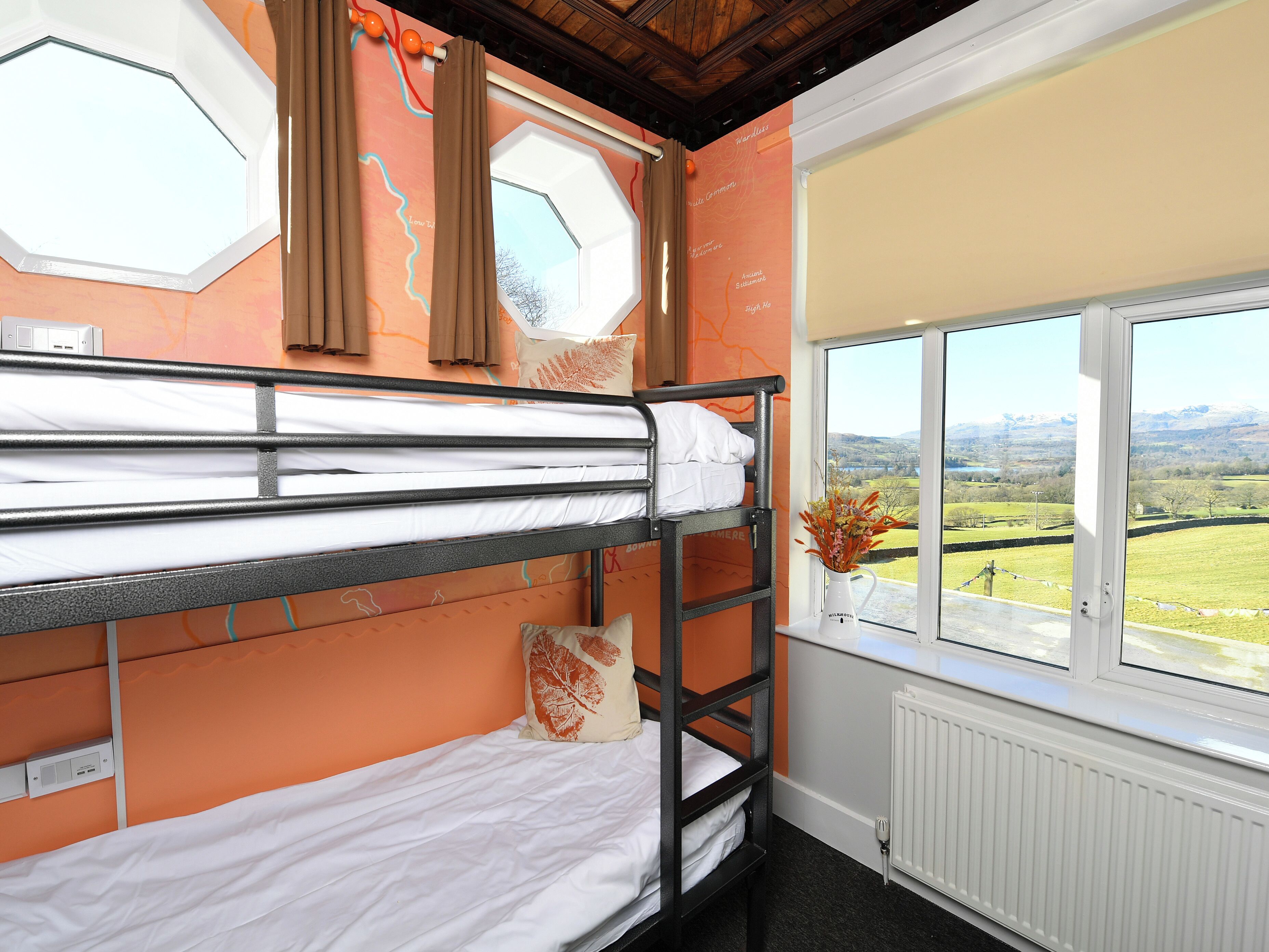 A bunk bed room with a window view of a landscape.