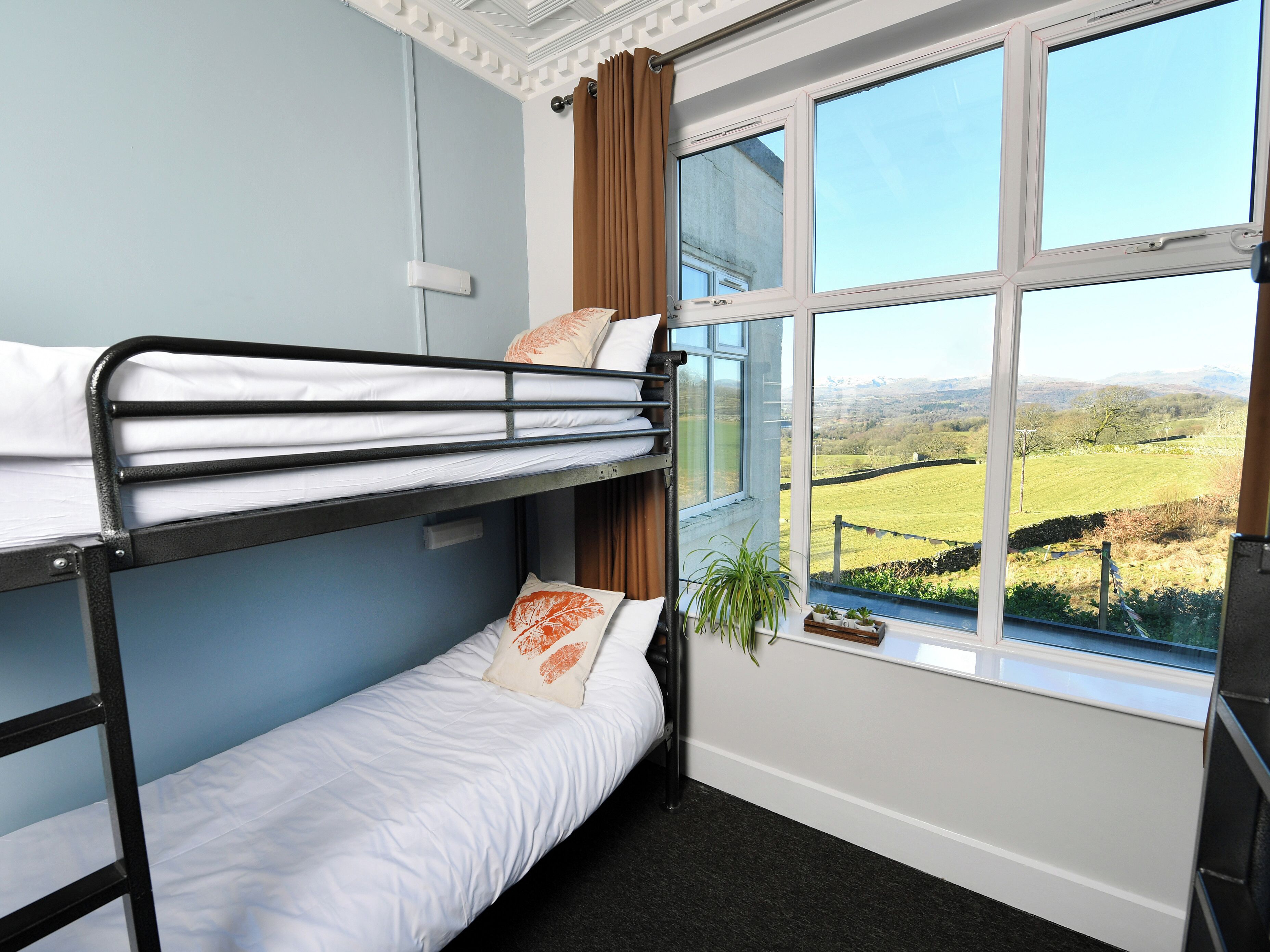 Dormitorio con literas y ventana que ofrece vistas al campo.