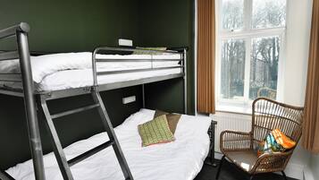 Quarto com beliche, janela, cadeira e radiador.