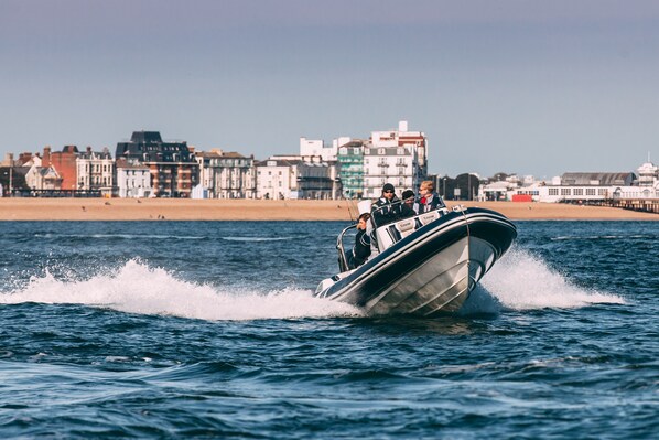 A boat with passengers on a body of water, with buildings in the background. - No Man's Fort (Portsmouth)