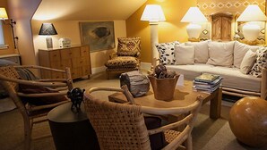 A cozy living room with a sofa, chairs, a coffee table, and lamps.