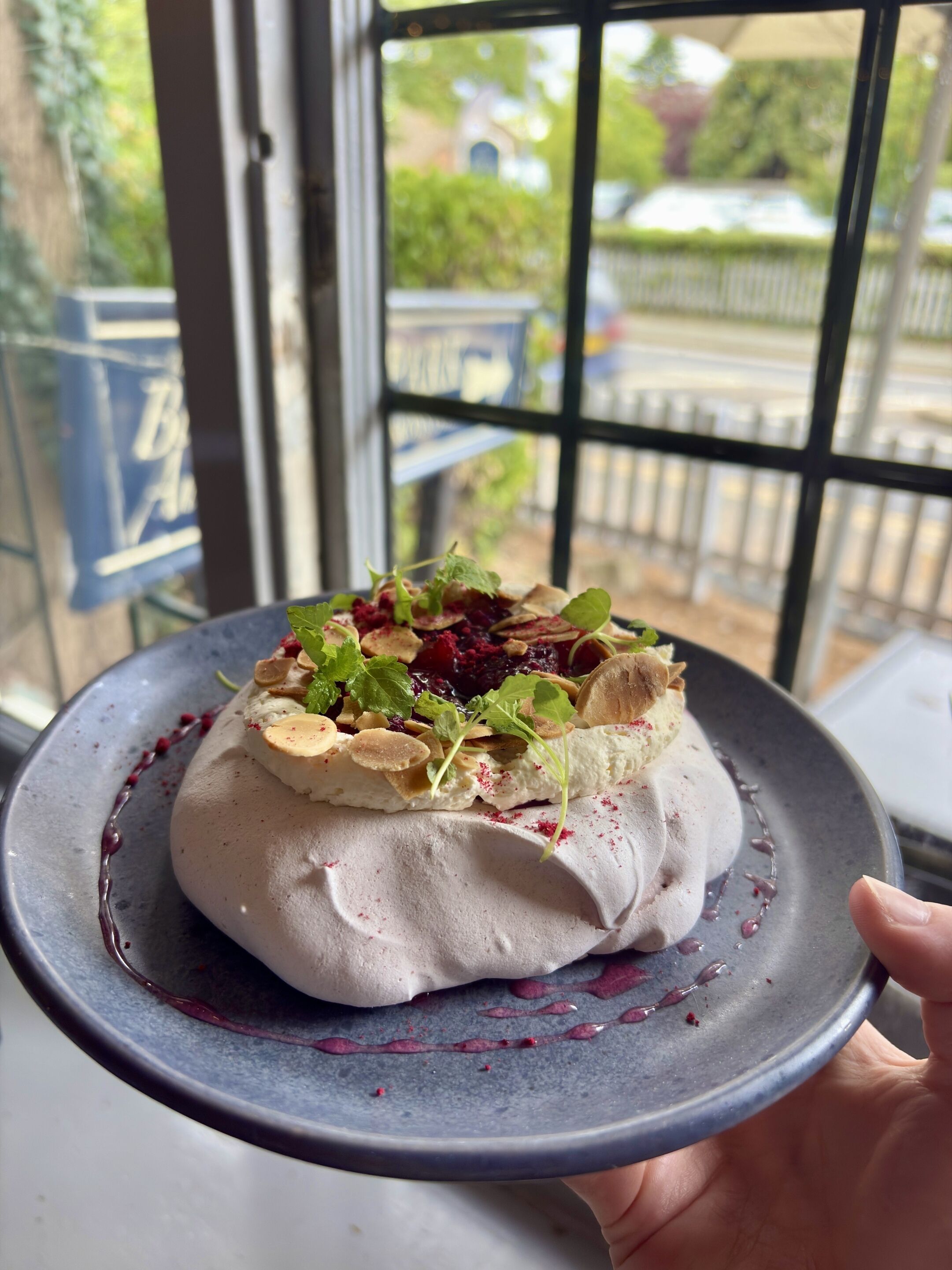 A dessert on a plate with a window view in the background.