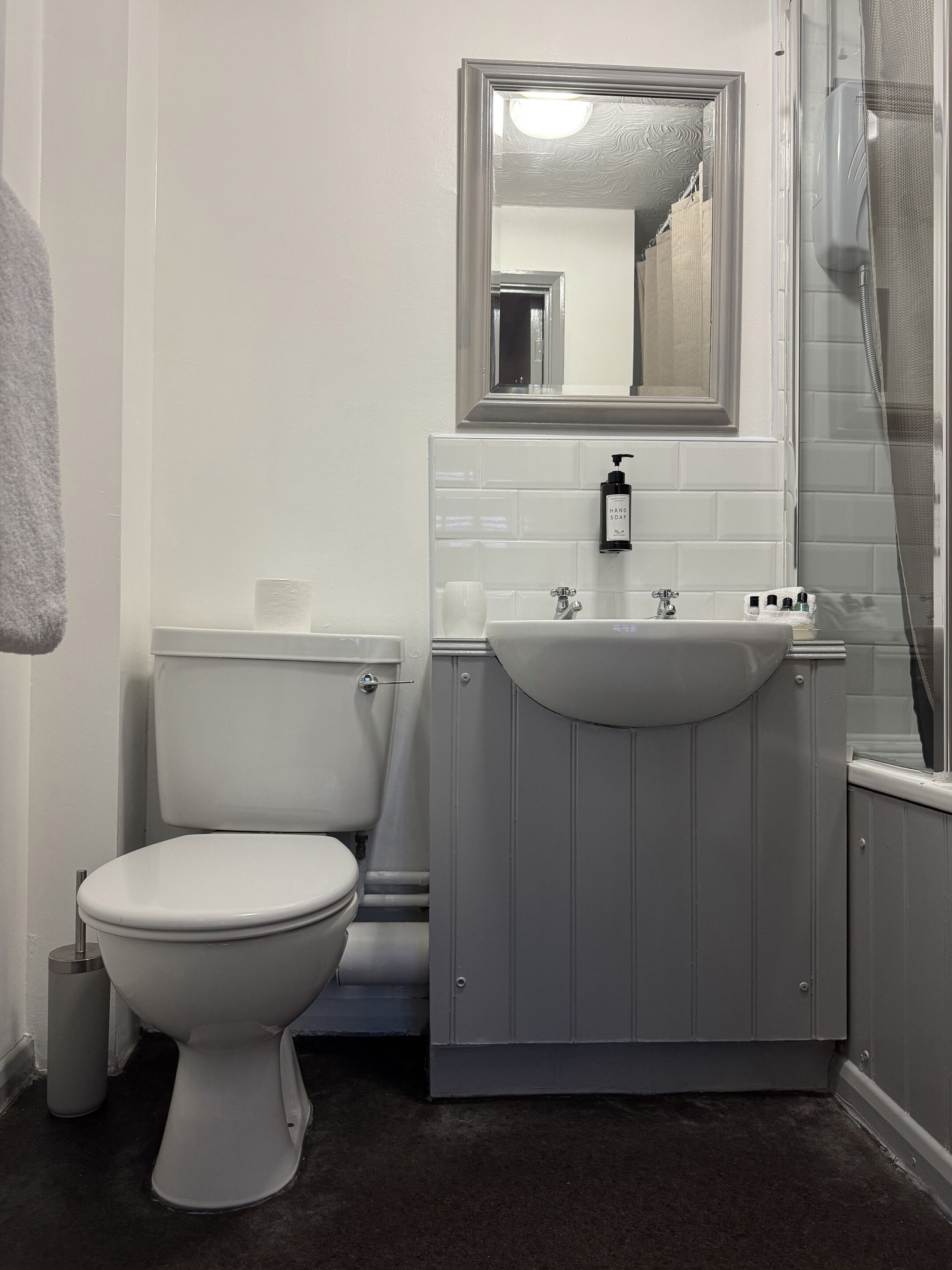 A bathroom with a toilet, sink, and shower.