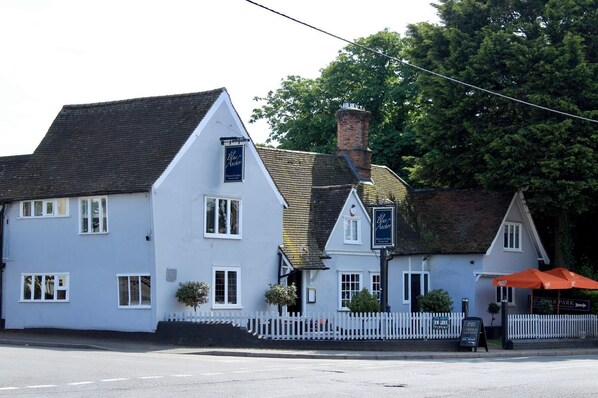 A traditional white building with a sign reading "The Blue Anchor."