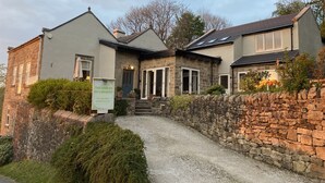 A two-story stone building with a gravel driveway leading to a front door. - The Gables Bed & Breakfast (Matlock)