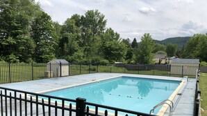 A rectangular swimming pool with a black metal fence surrounding it. - Lantern House Motel (Great Barrington)