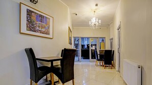 A dining area with a table and chairs, a chandelier, and a framed picture on the wall. - OYO Weaste Hotel (Salford)