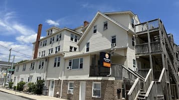 Un hotel de varios pisos con un llamativo letrero que dice 'Wellington Hotel & Suites', fachada de ladrillo y balcones de madera.