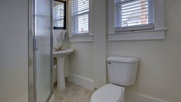 Ein Badezimmer mit Toilette, Waschbecken und Duschbereich.