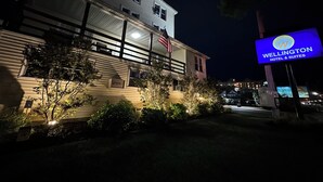 Un hotel con un cartel que dice 'Wellington Hotel & Suites' de noche.