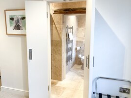Un pasillo con un baño y una puerta que da a una habitación.