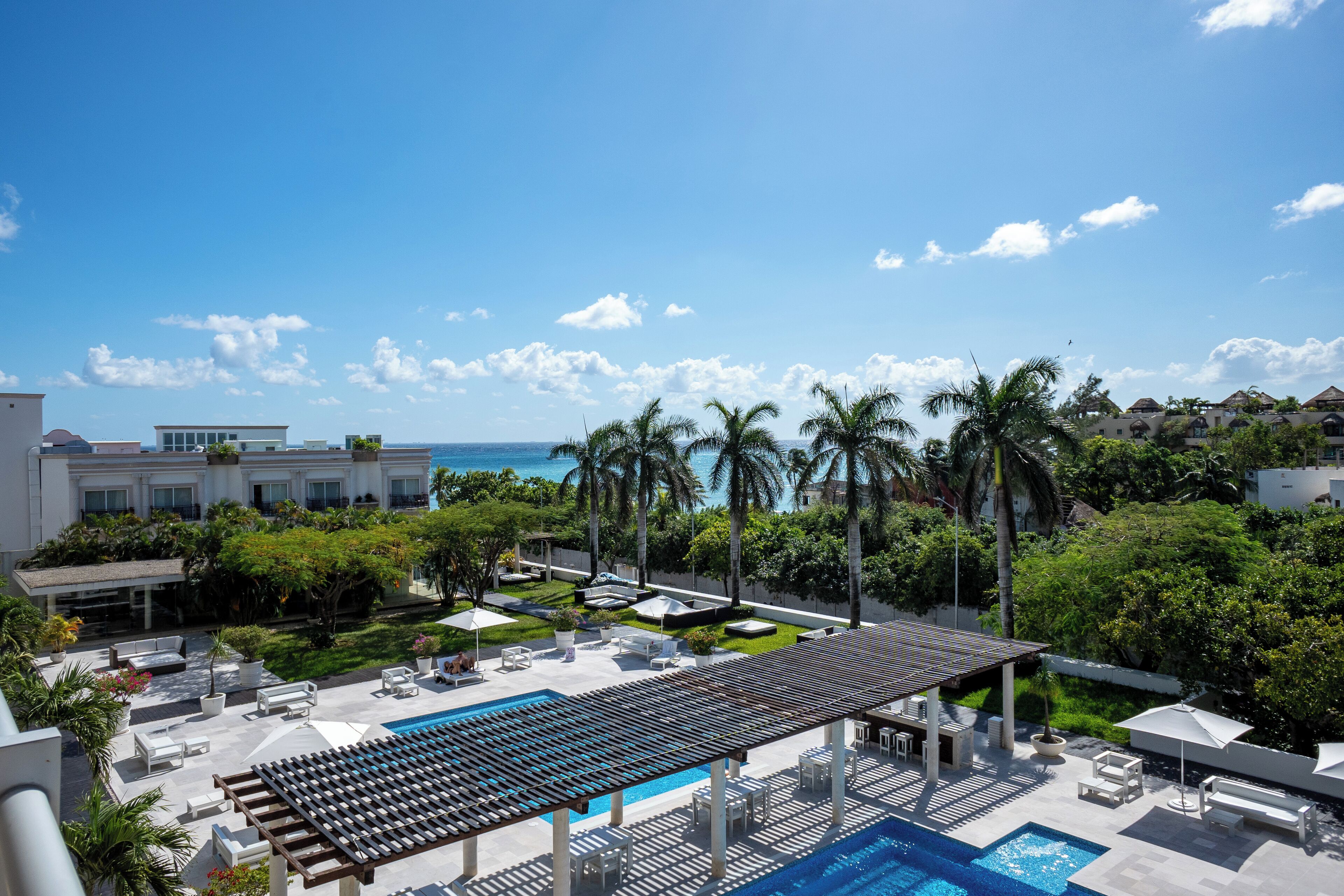 Alberca al aire libre, sombrillas en la alberca y camastros 