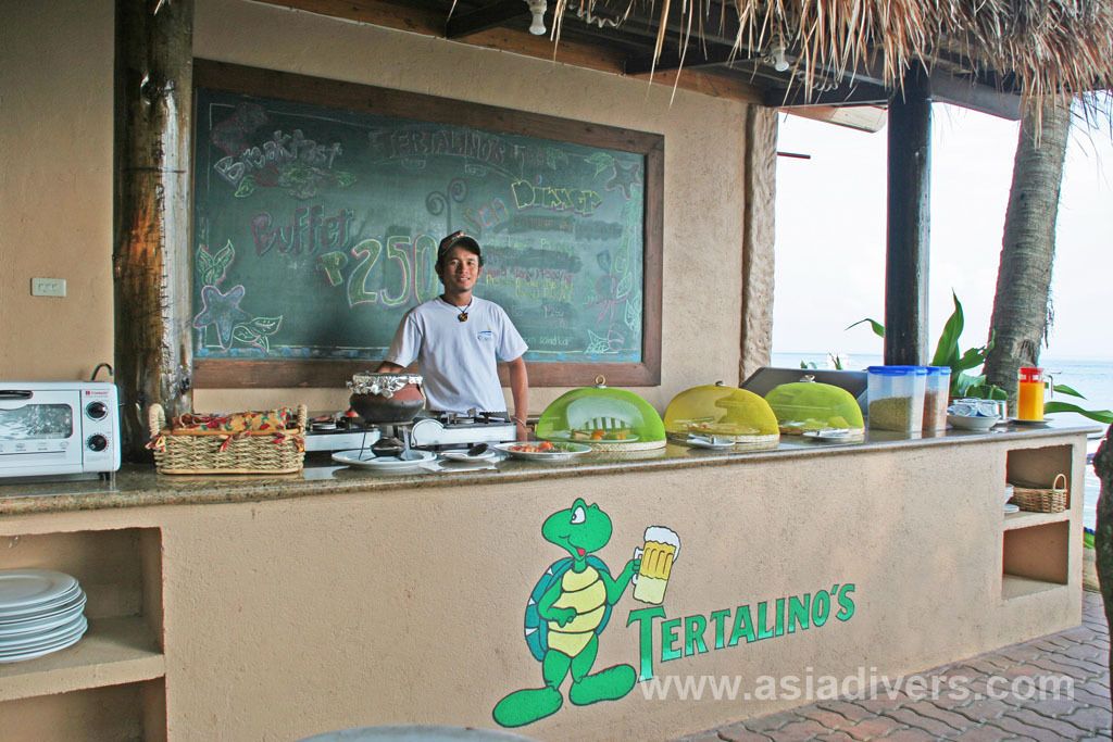 A buffet counter with a chalkboard menu, a turtle logo, and various food items displayed.