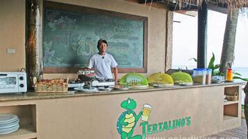 A buffet counter with a chalkboard menu, a turtle logo, and various food items displayed.