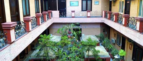 Un patio de varios niveles con plantas en macetas y una escalera central.