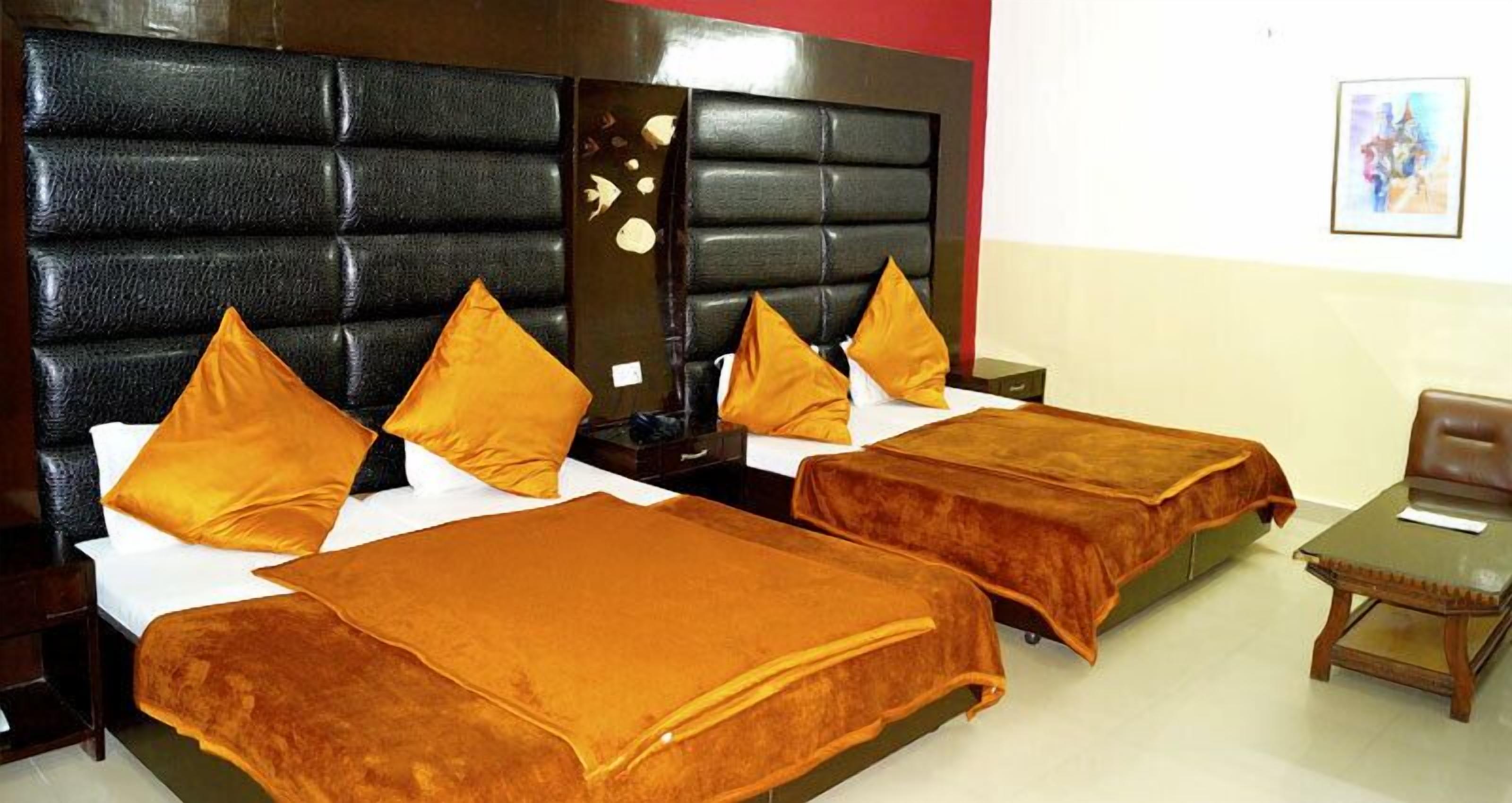 Une chambre d’hôtel avec deux lits, chacun doté d’une tête de lit et d’oreillers assortis.