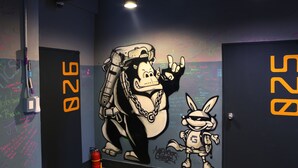 Pared con arte callejero, incluyendo una figura grande y un personaje más pequeño, y el número 928 en las puertas.