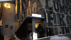 Un edificio con un cartel que dice "RECEPTION & CAFE" y una escalera que conduce a la entrada.